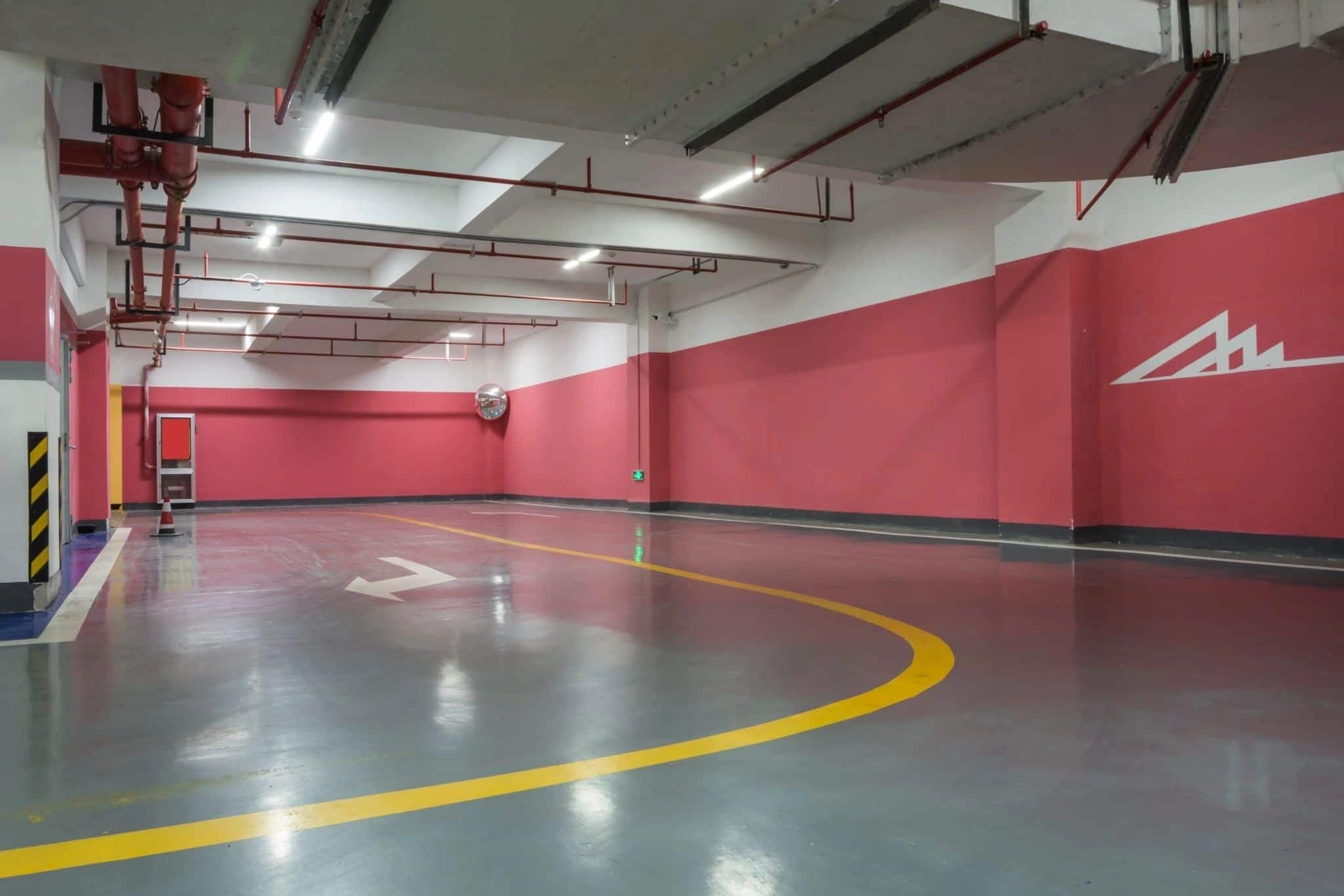 Parkdeck mit roter Beschichtung, weißen Stellplatzmarkierungen und Stützen